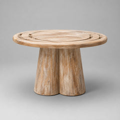 A round wooden side table with a natural weathered finish, featuring a thick two-leg base and decorative cutouts on the tabletop, shown against a neutral gray background.