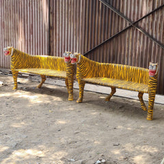 Two tiger-themed benches with striped patterns and red masks on a concrete surface.