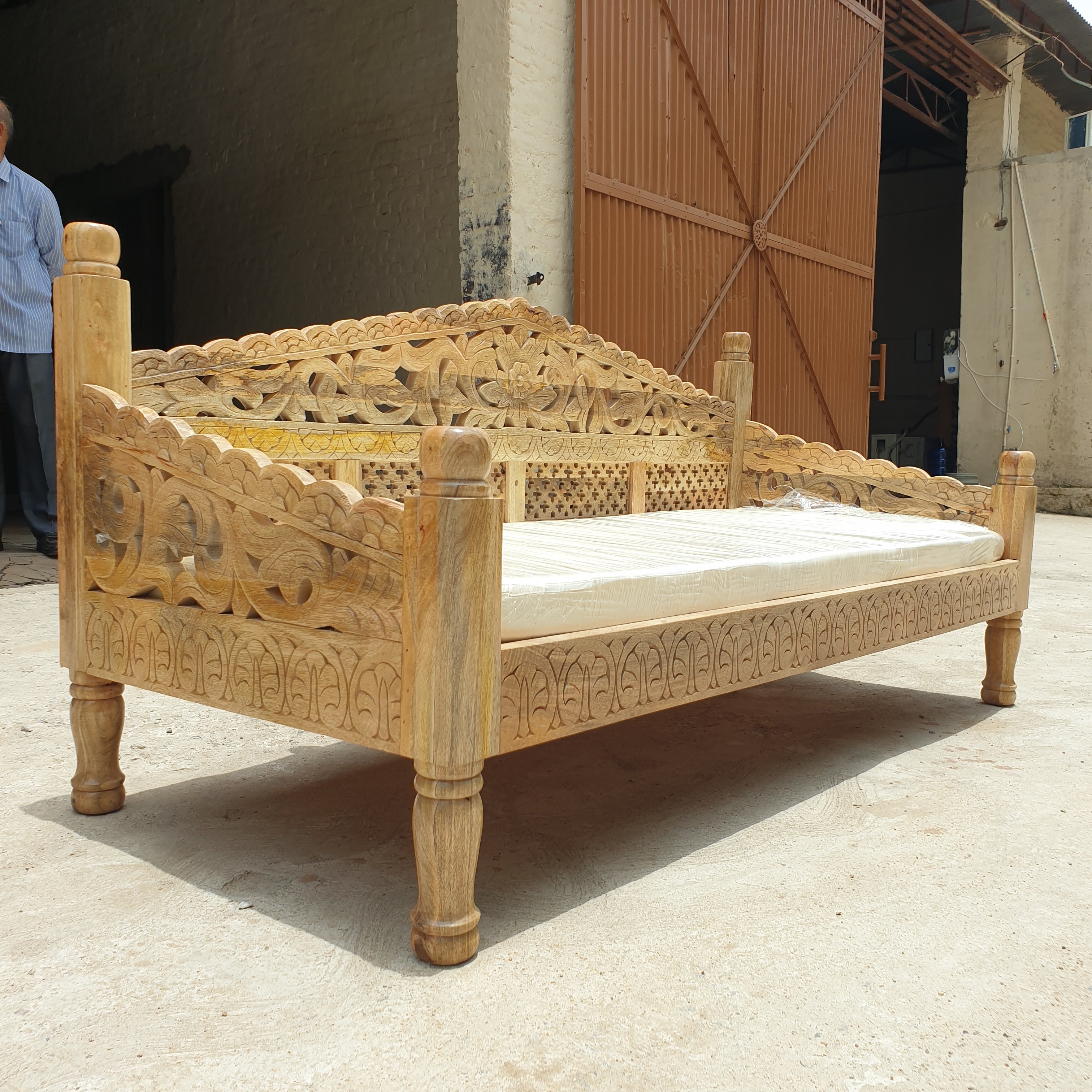 Intricate floral and vine carving on wooden daybed backrest