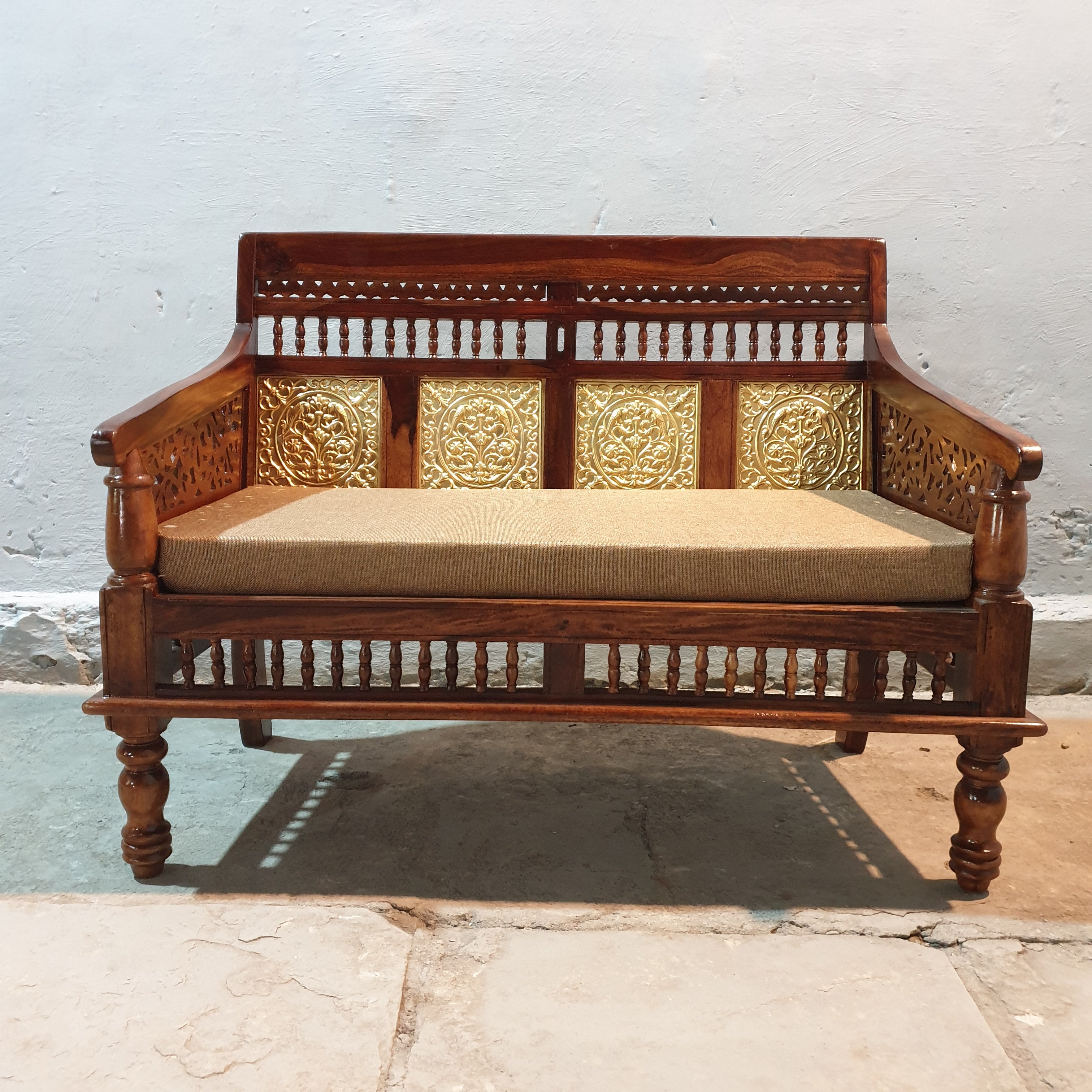 Ornate brass floral panels on traditional Indian wooden daybed