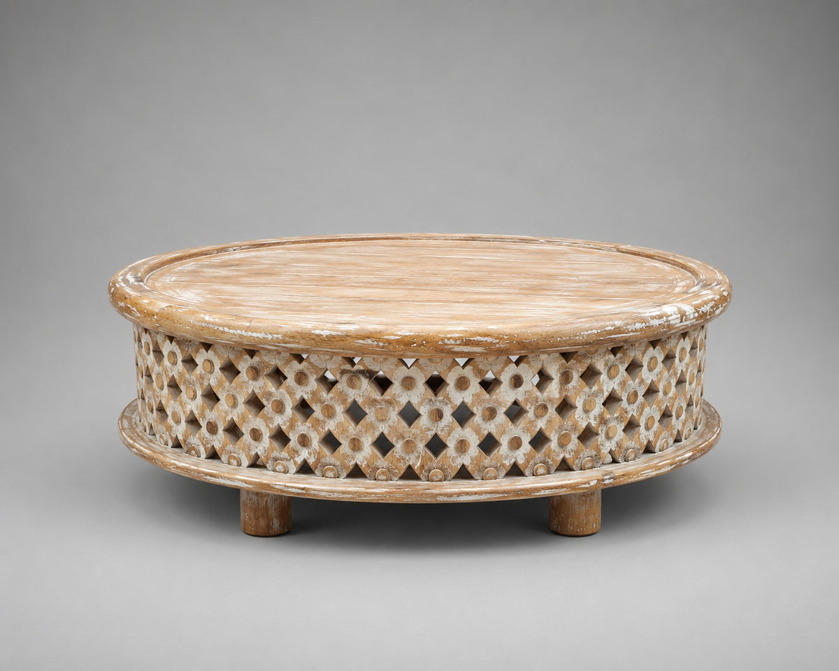 Whitewashed low round mango wood coffee table with geometric floral lattice carving and raised circular tabletop.