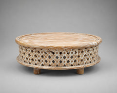Whitewashed low round mango wood coffee table with geometric floral lattice carving and raised circular tabletop.