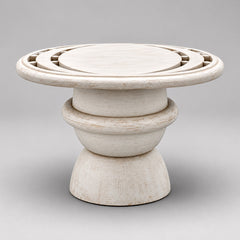 Whitewashed mango wood pedestal coffee table with geometric carved circular top and sculptural rounded base.