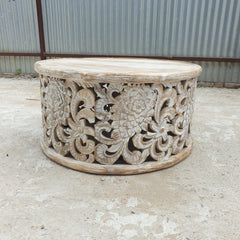 Whitewashed round mango wood coffee table with intricate floral openwork carving, 90 cm diameter.